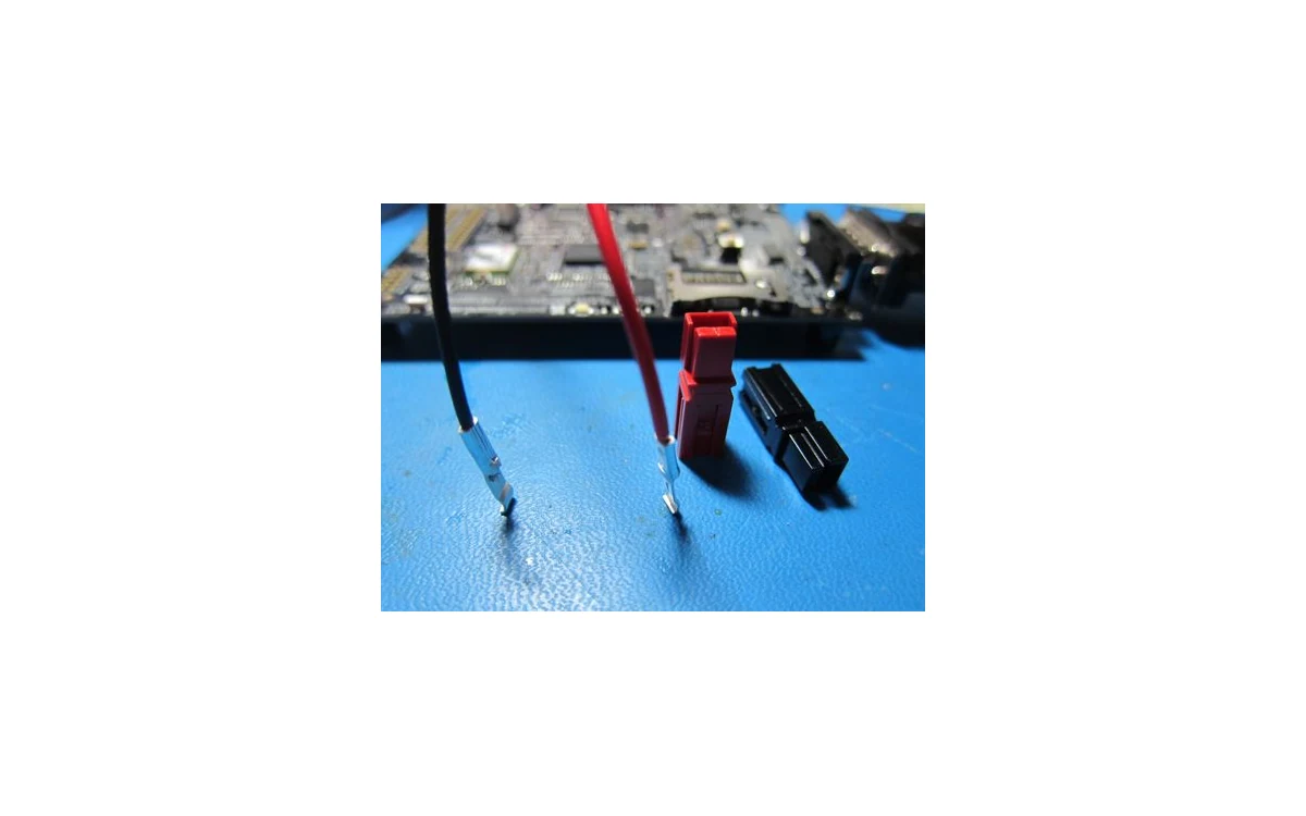 Crimped Powerpole wire contacts beside separate red and black connector housings.