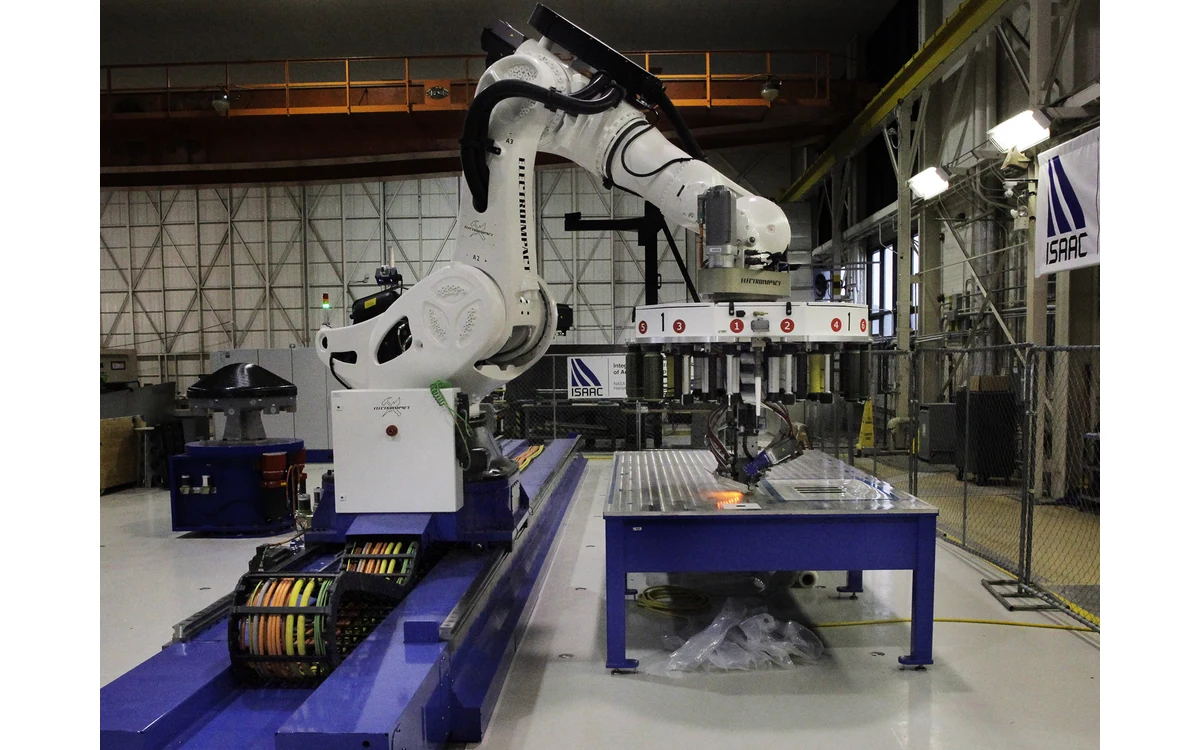 NASA ISAAC robot placing composite ribbons on a flat manufacturing tool.