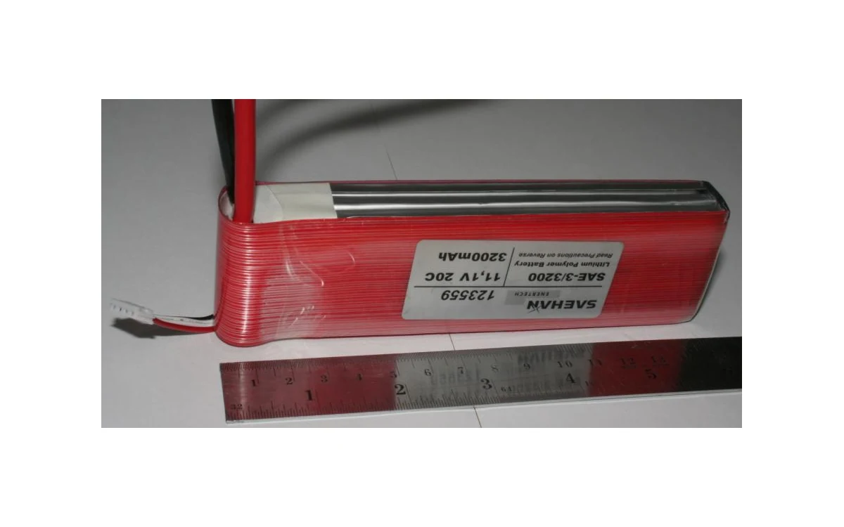 Lithium-polymer RC model battery pack with power leads and ruler.