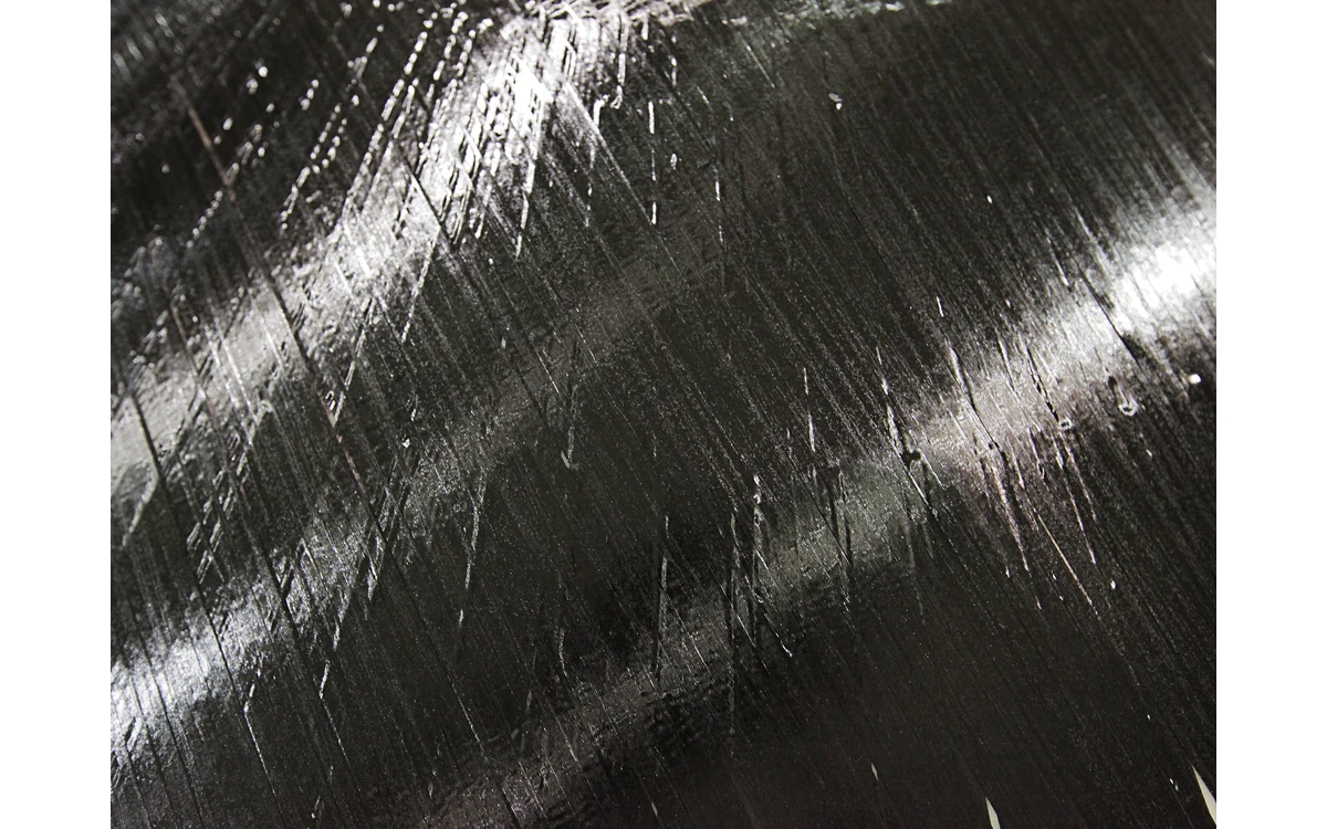 Reflective surface of a carbon-fiber-and-epoxy ribbon sheet.